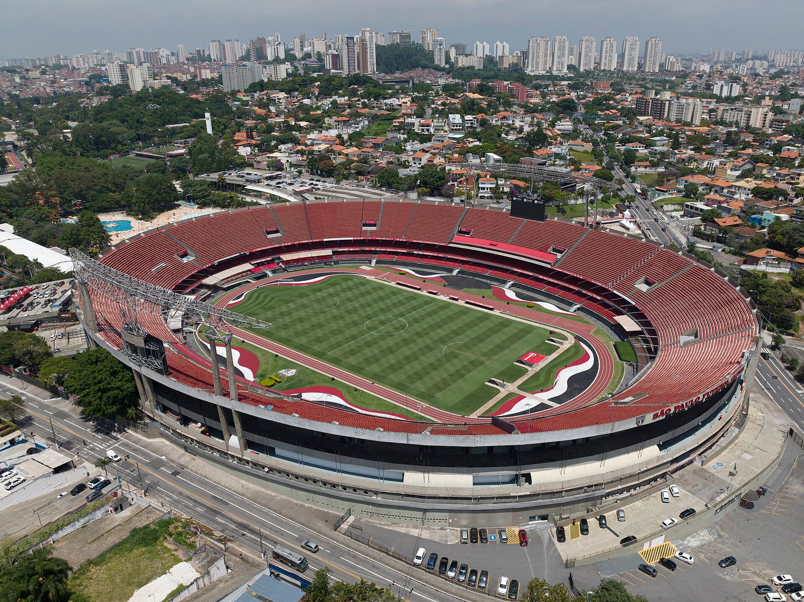 Vista aérea do Estádio do Morumbi, em São Paulo, com arquibancadas vermelhas e o campo de futebol