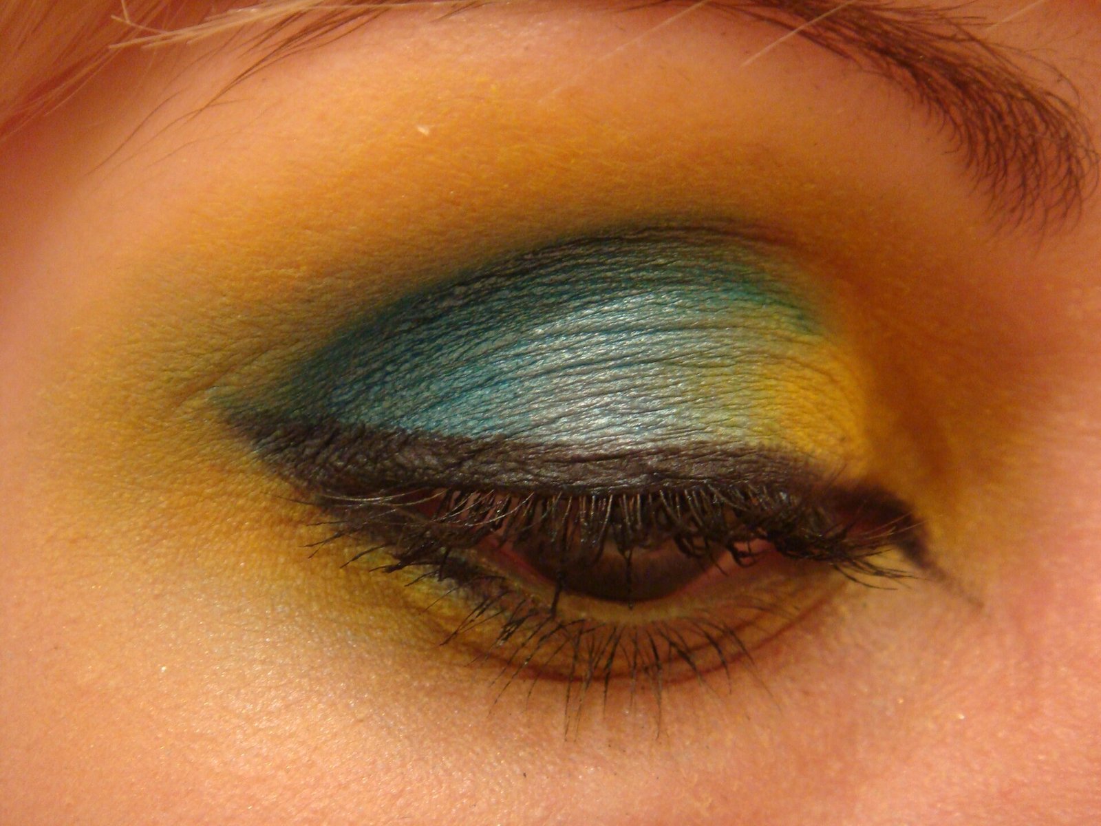 Close de olho com sombra colorida em amarelo e azul metálico