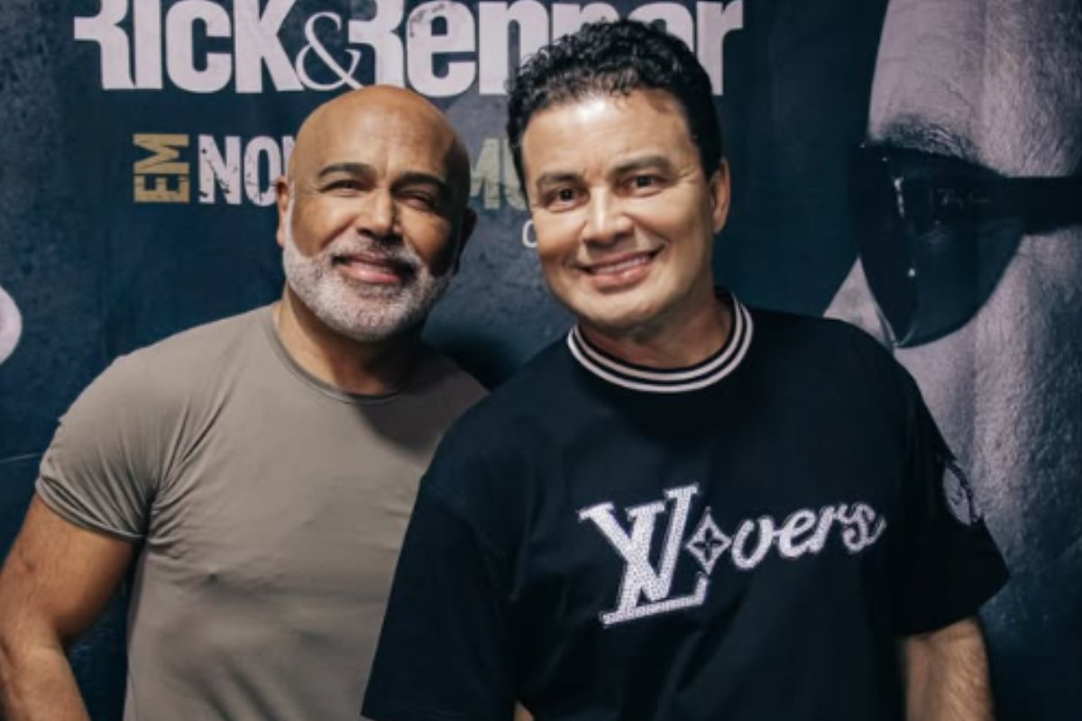 Rick e Renner sorrindo lado a lado em foto de divulgação, com o nome da dupla em um banner ao fundo