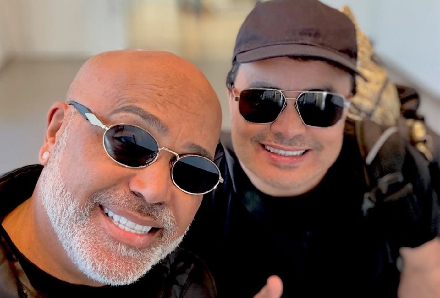 Rick e Renner de óculos escuros em registro antigo dos dois em um aeroporto, imagem usada por Renner na homenagem de um mês da morte do parceiro